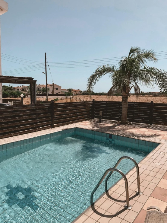 an empty swimming pool surrounded by palm trees