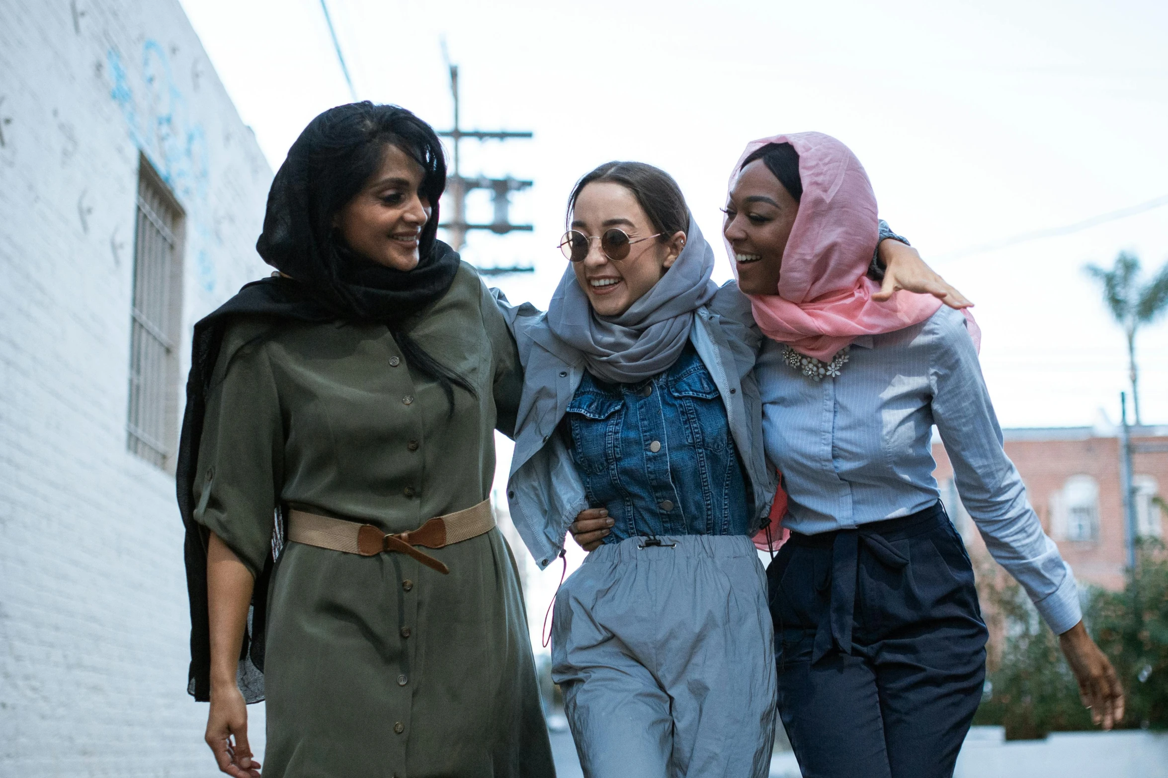 three women walking down the street and smiling