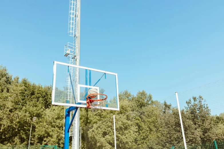 an empty basketball hoop set against the blue sky