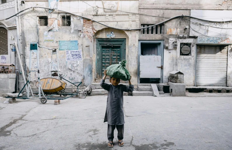 a man holding two green umbrellas walking in the street