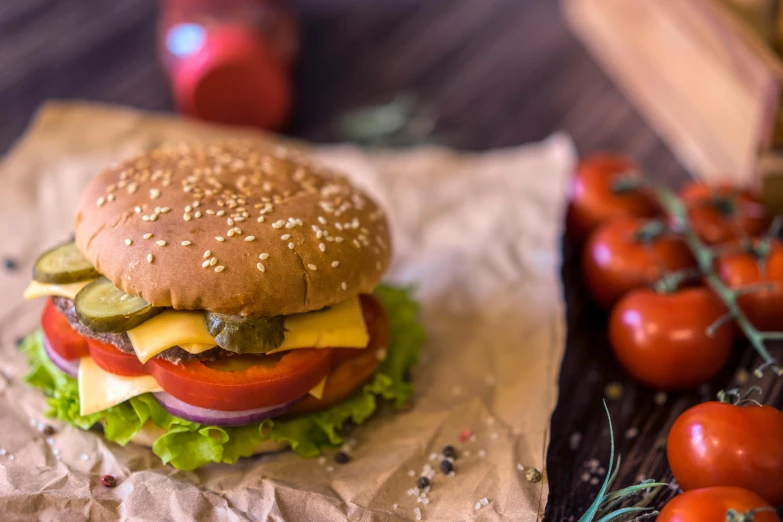 a cheeseburger on rye bread with pickles and tomatoes