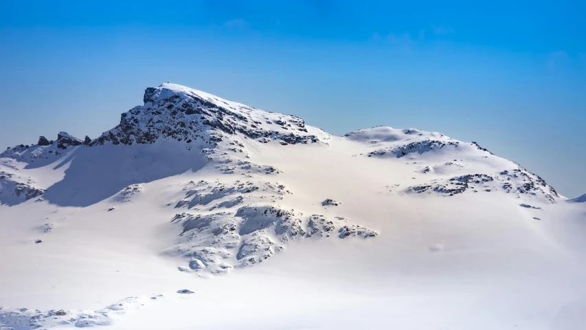 a lone snow skier is seen in the snowy mountains