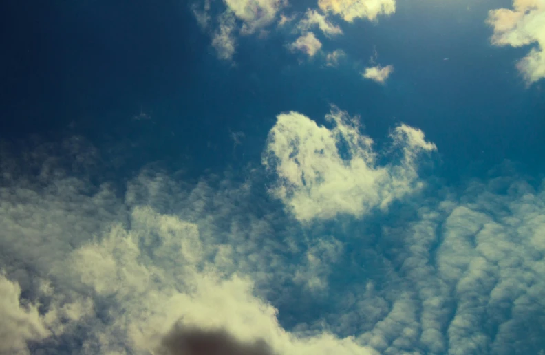 a jetliner flying in front of some cloudy skies