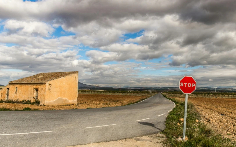 a stop sign in front of an old stone house