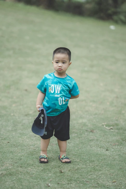 a little boy with a baseball glove and t - shirt