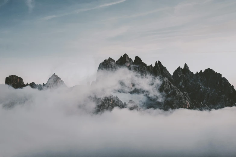 a mountain is surrounded by fog and rocks