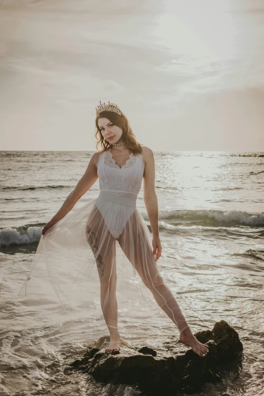 a  poses in front of the ocean