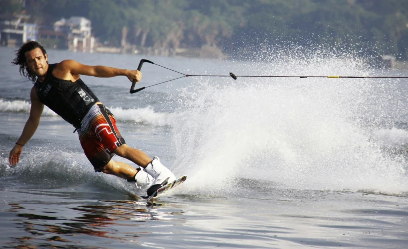 a woman water skiing while holding onto the handle of her boat