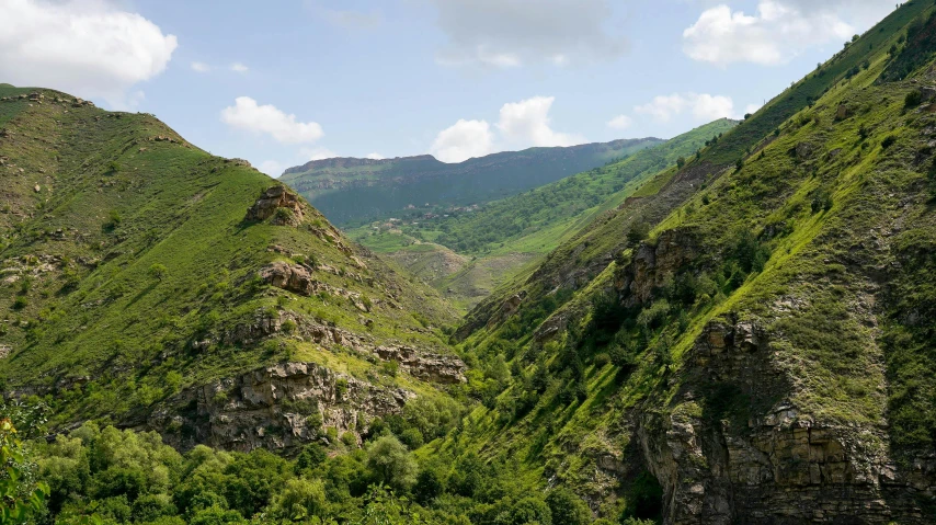 this is a very steep cliff surrounded by some green hills