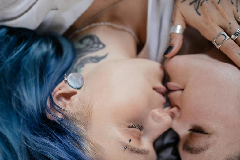 two women with piercings laying next to each other