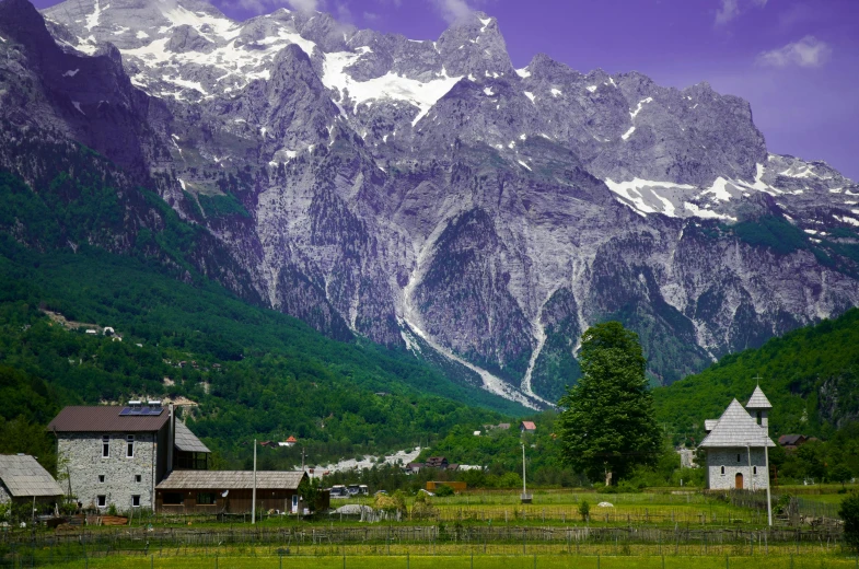 a mountain scene has snow covered mountains in the background