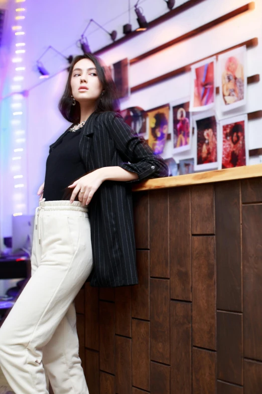 a woman leaning on a wall and looking up