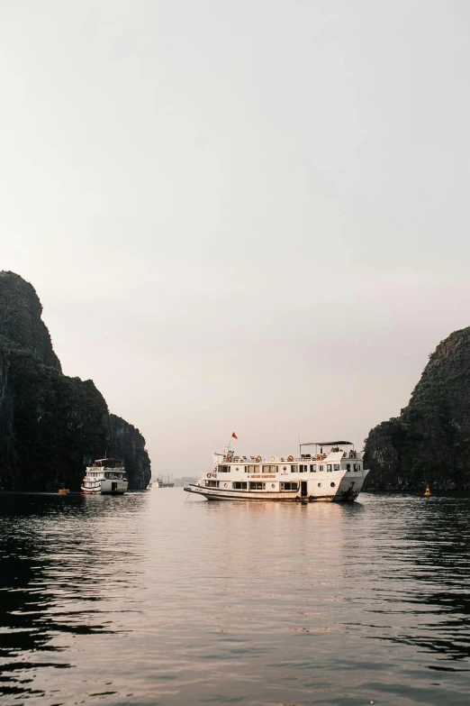 a boat in the ocean with mountains behind it