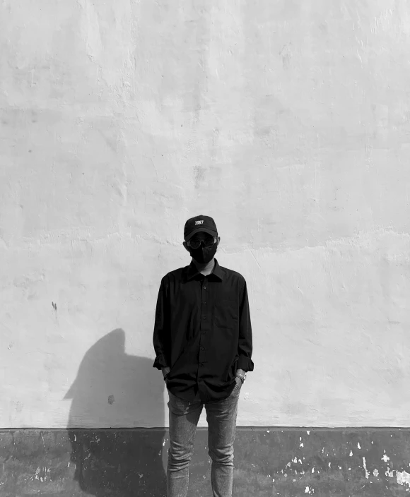 a man standing in front of a wall wearing a helmet