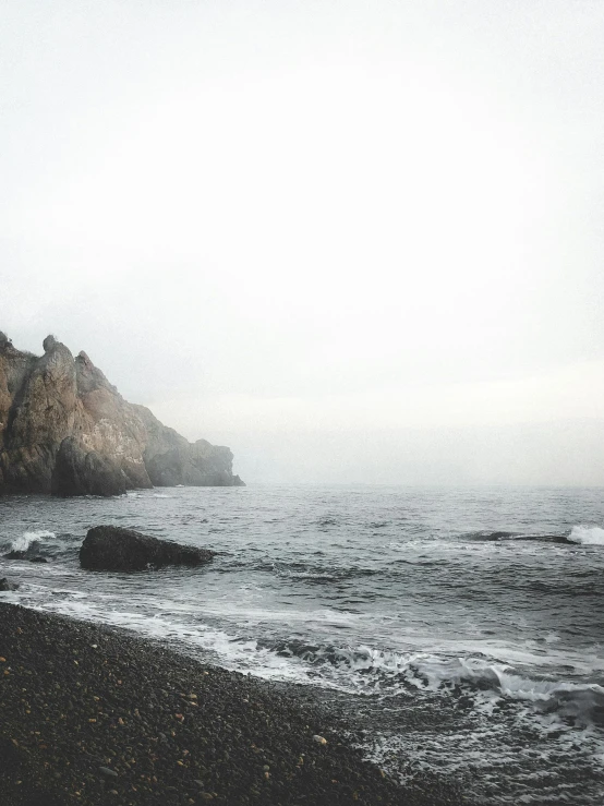 a man standing on the beach looking out to sea