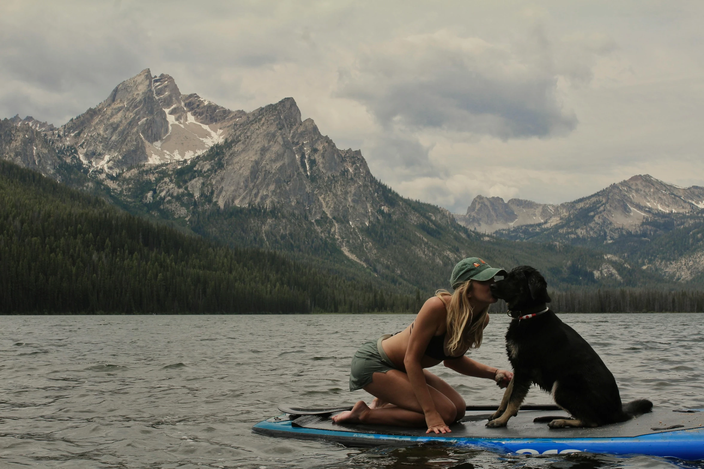 the woman and her dog are enjoying a day on the lake