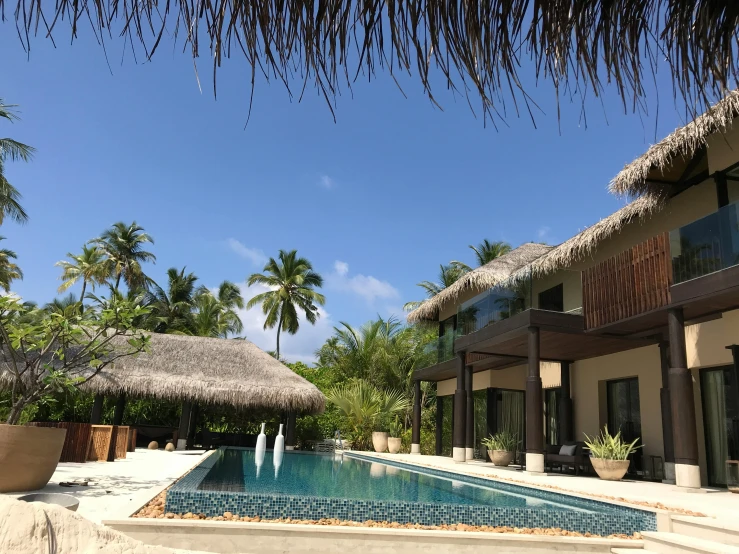 a resort building with a pool surrounded by palm trees