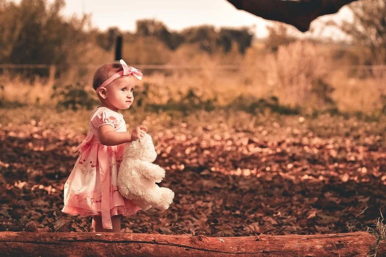 a little girl is holding her dress while wearing a bow