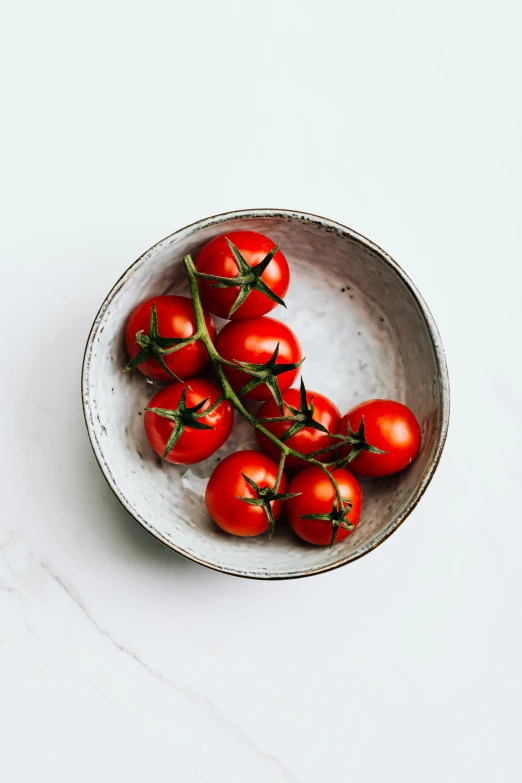 tomatoes are shown in a bowl on a table