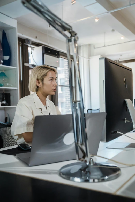 a woman sitting at a desk looking over her shoulder