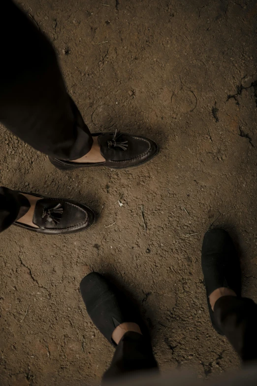 two feet are visible in front of some people wearing black shoes