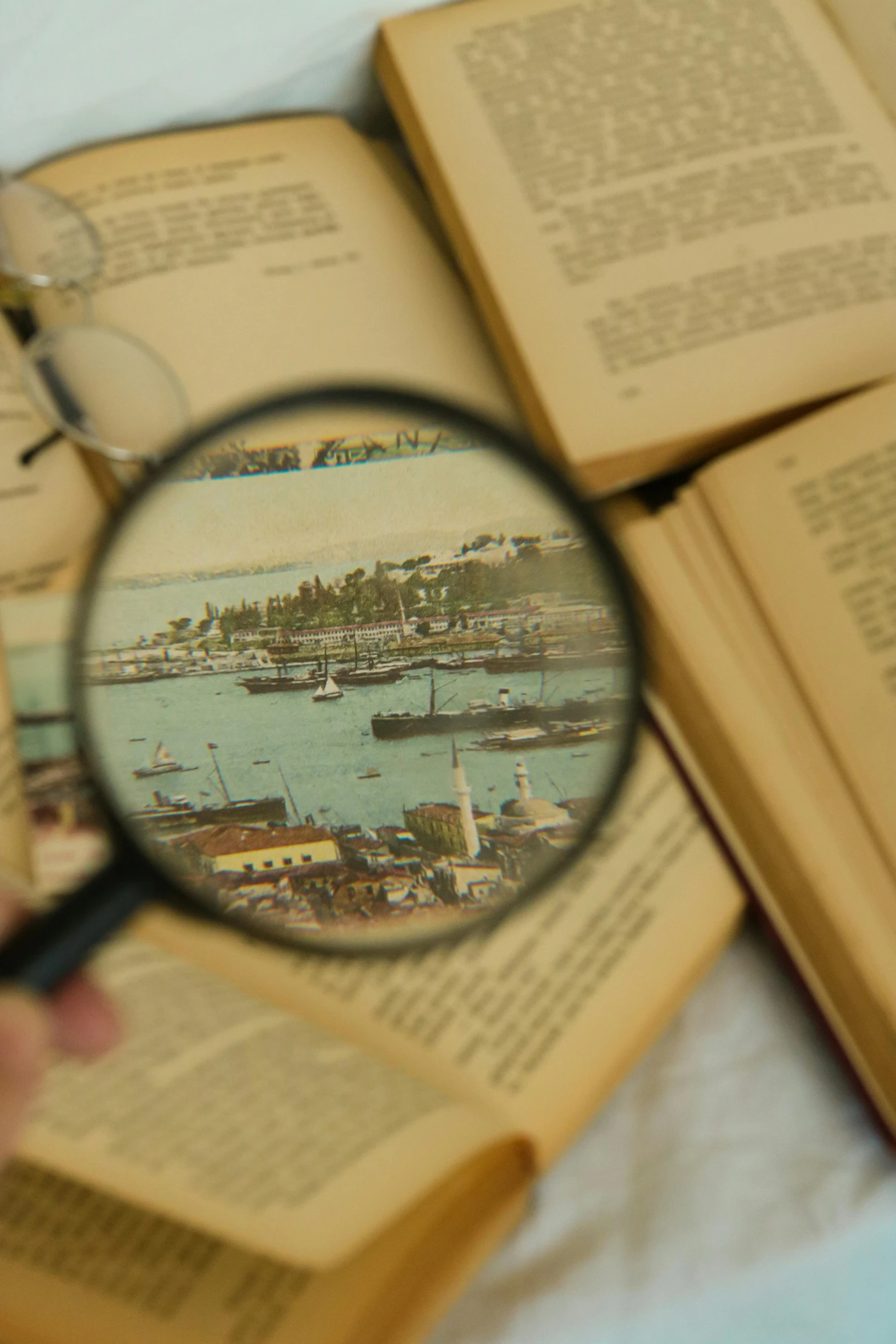 a person is holding up a magnifying glass to look through the book