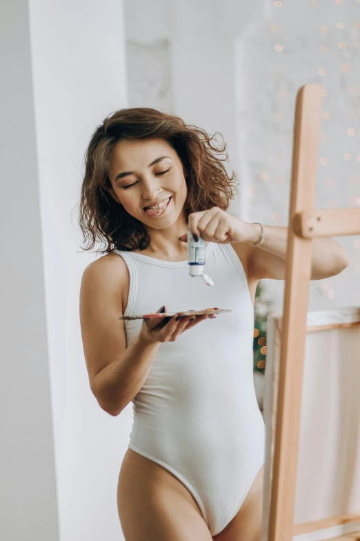 a pregnant woman looking at her smartphone while wearing white underwear