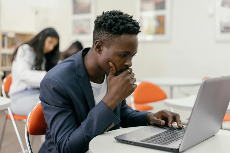 a young man looking at his computer screen in the liry