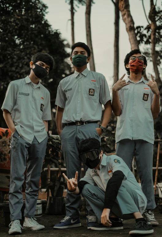 a group of men wearing face masks and standing around