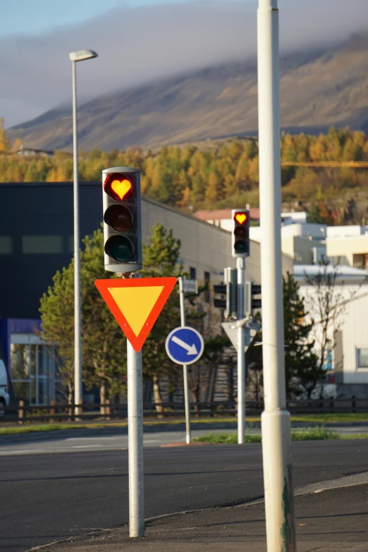 traffic lights with a heart and arrow on them on an empty street