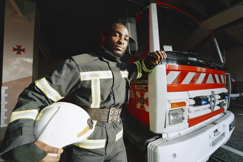 a man in uniform is standing next to a firetruck