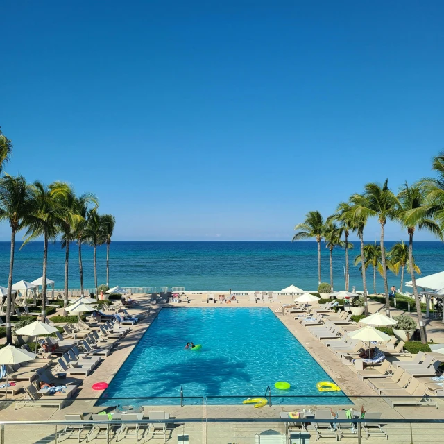 a large swimming pool in front of the ocean