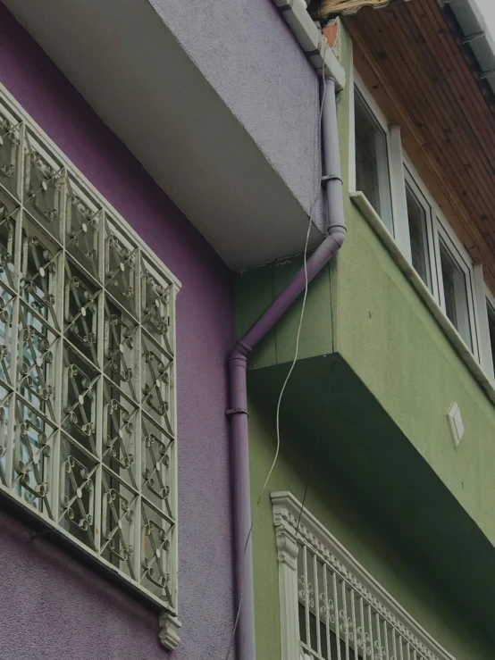 an apartment building with a green, purple and yellow facade