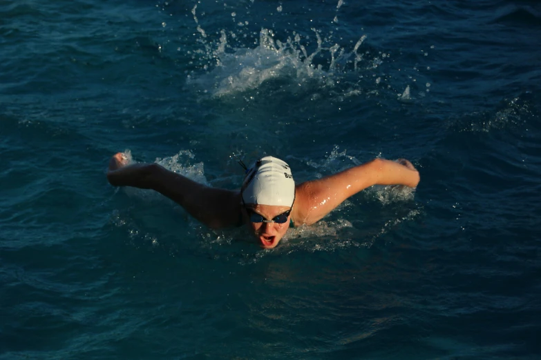 a man in the water wearing a white visor