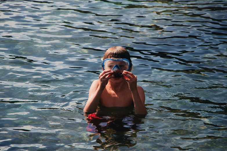 a girl in goggles and a mask covers her face with her hands