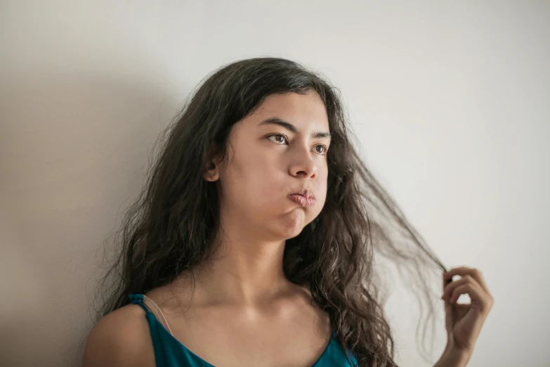 young woman making a face while brushing her hair