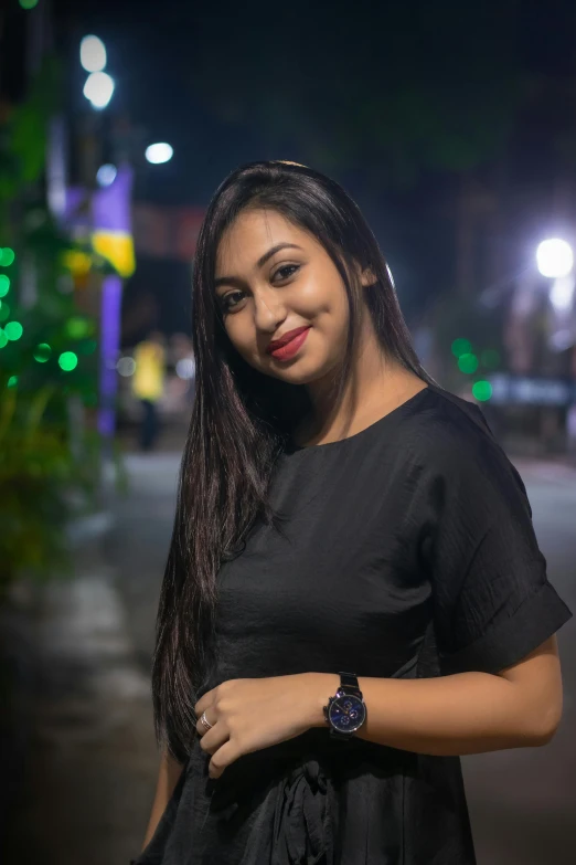 an indian woman in a black dress at night