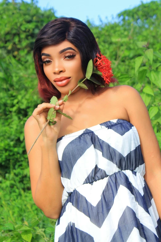 a beautiful woman in a black and white dress posing with flowers