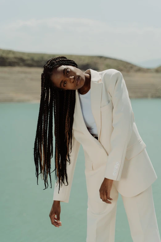 a woman is posing in front of a body of water