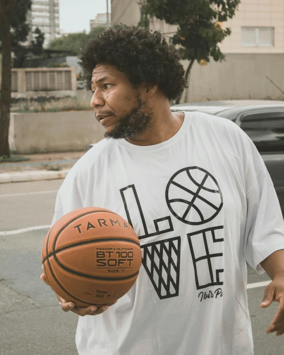 a man is holding a basketball while walking down the street