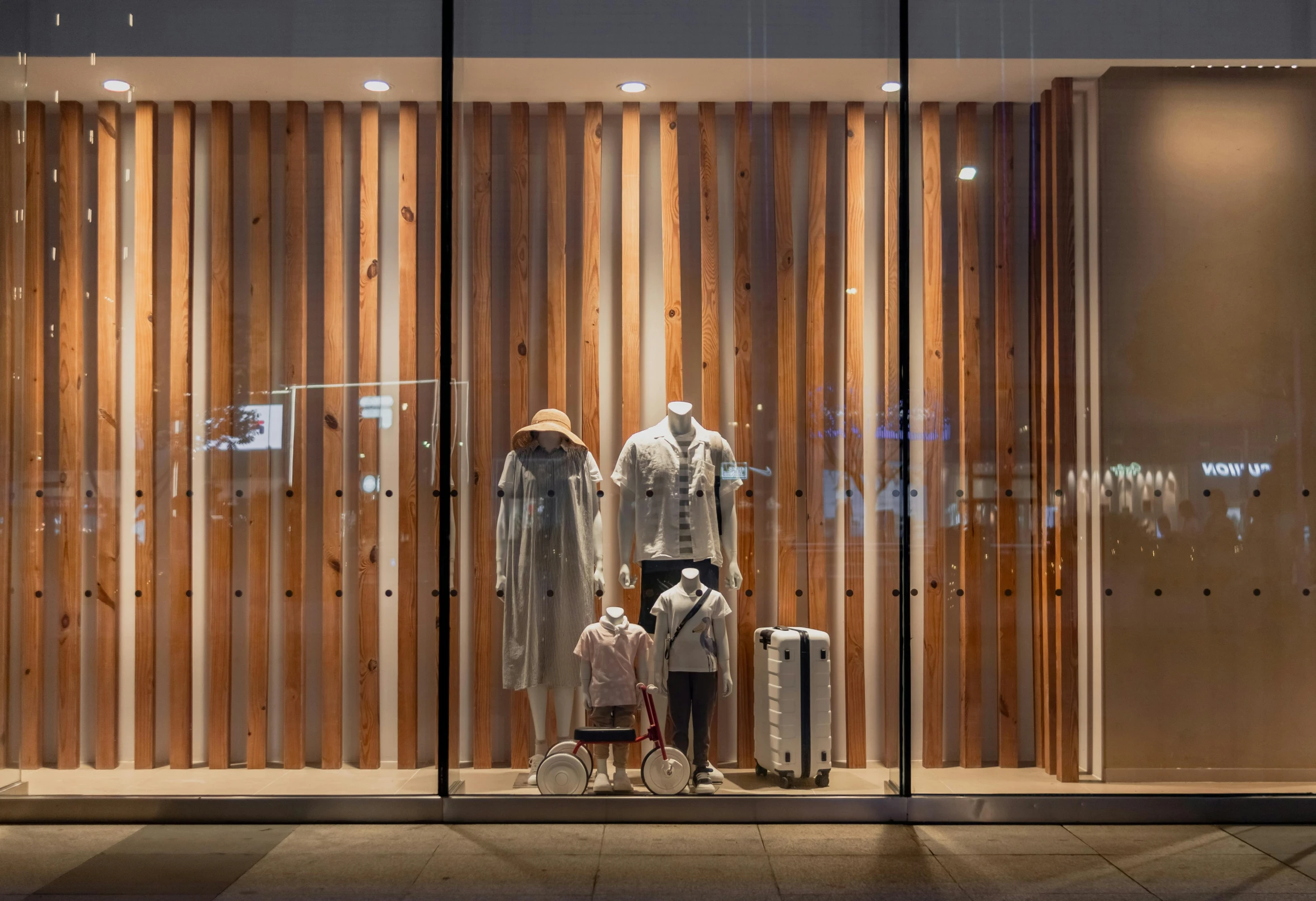 a store window featuring a woman and children's luggage