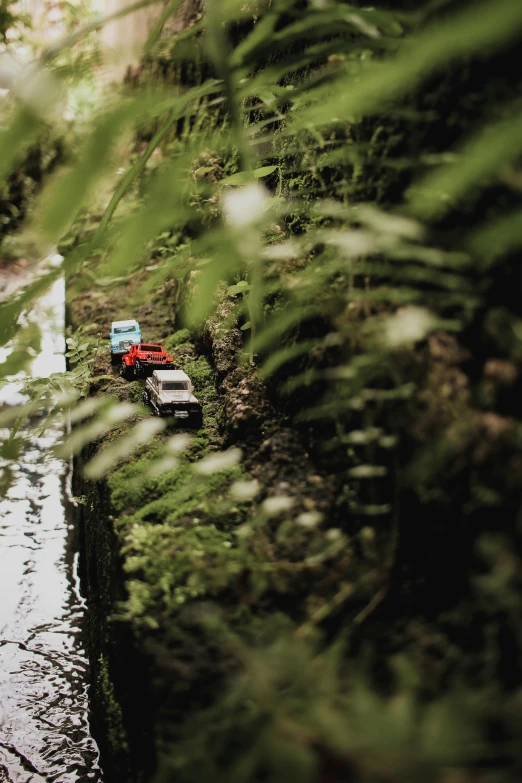 cars on the street sitting next to a body of water