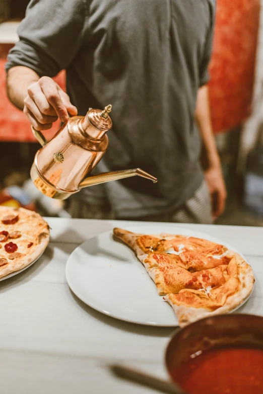 a man pours pepperoni on top of two pizza slices