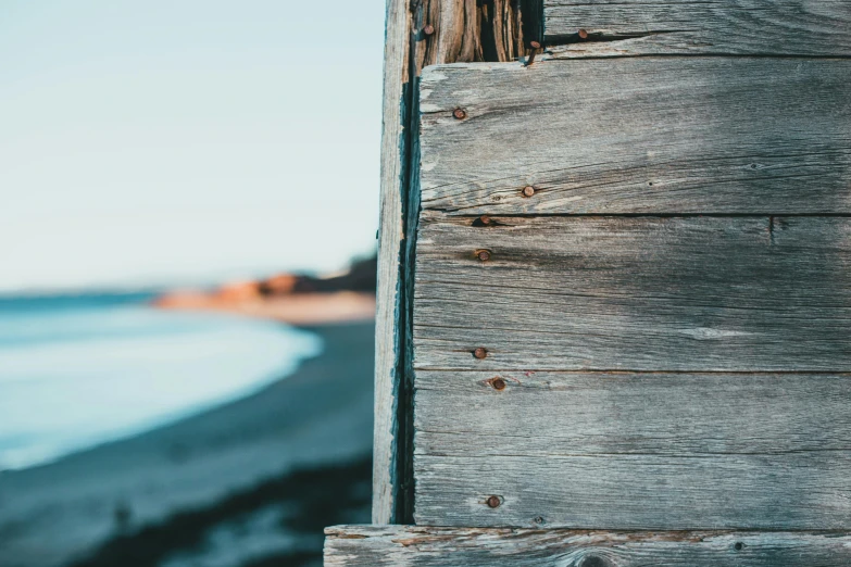 closeup of wood siding near beach with ocean in background