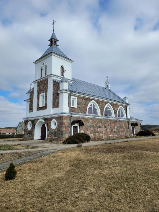 a tall building with a steeple surrounded by grass