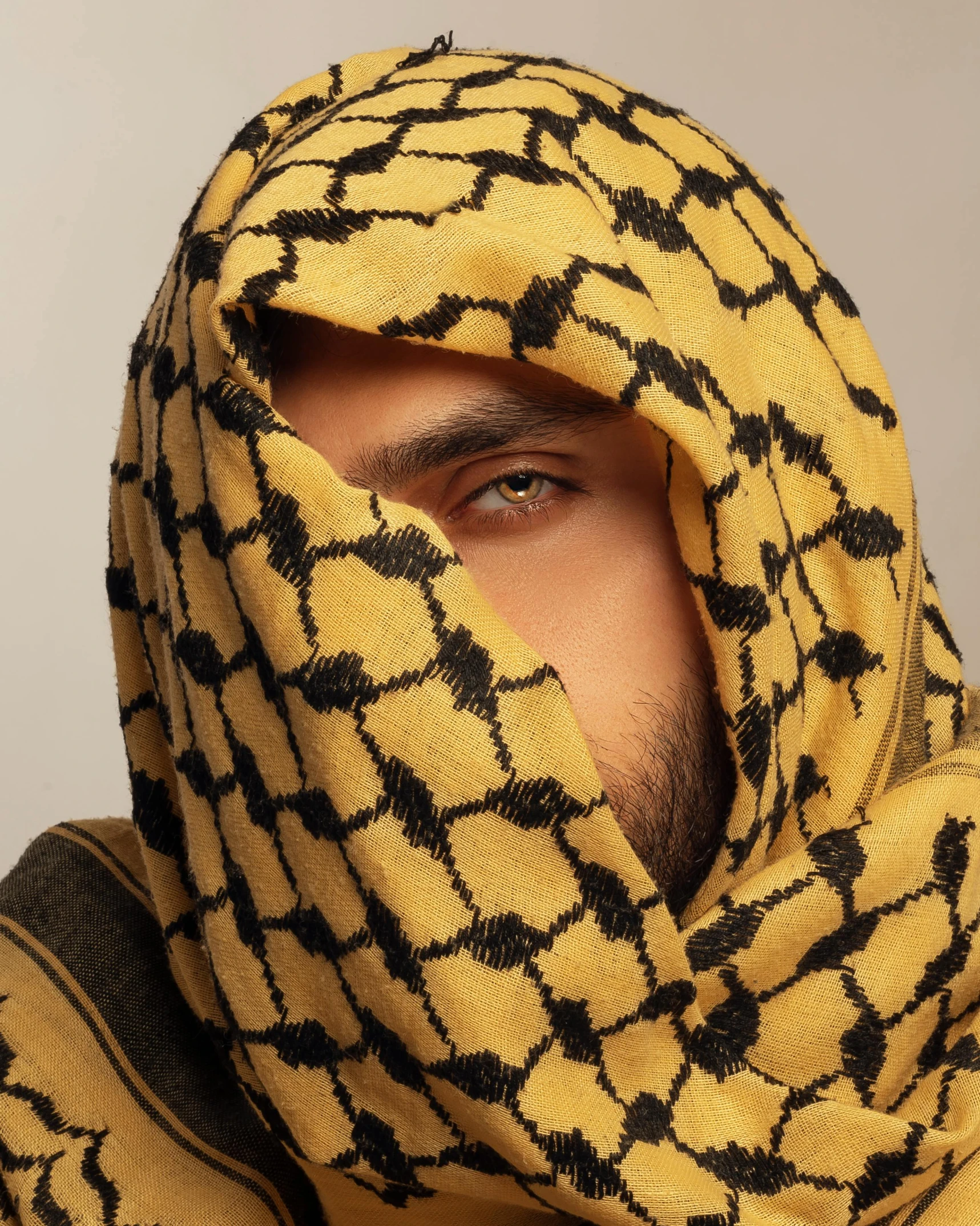 a young man wearing a yellow and black patterned hoodie