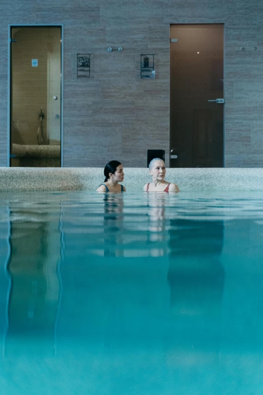 an adult and baby in a large pool