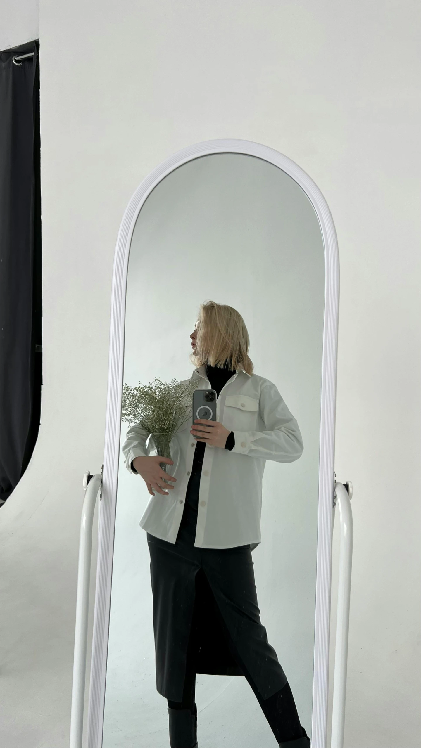 the woman is standing near the giant mirror