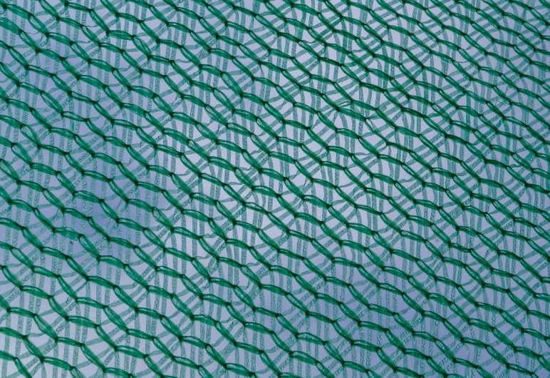 an abstract pattern consisting of green netting and a blue sky