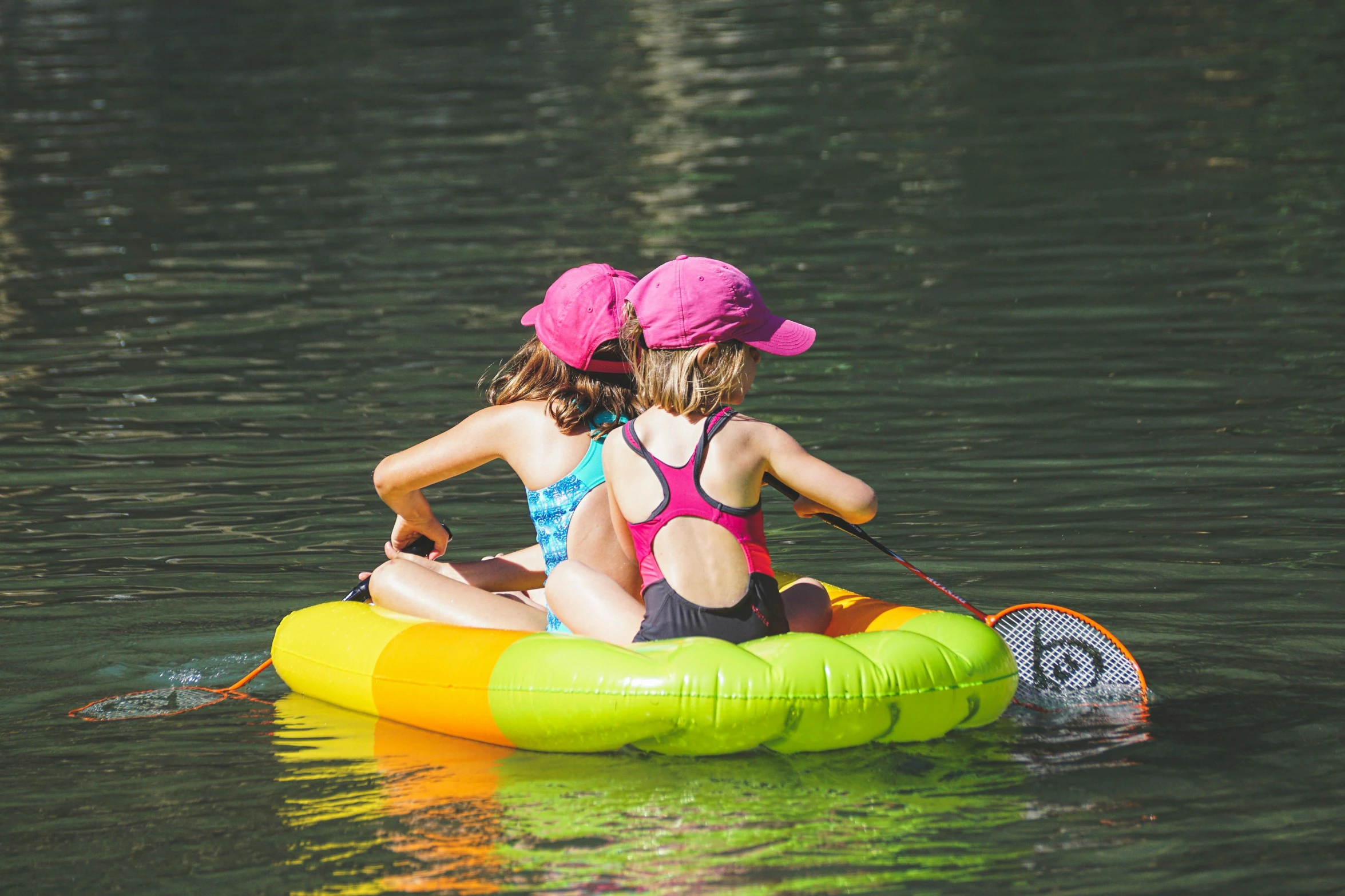 two girls are boating in the lake